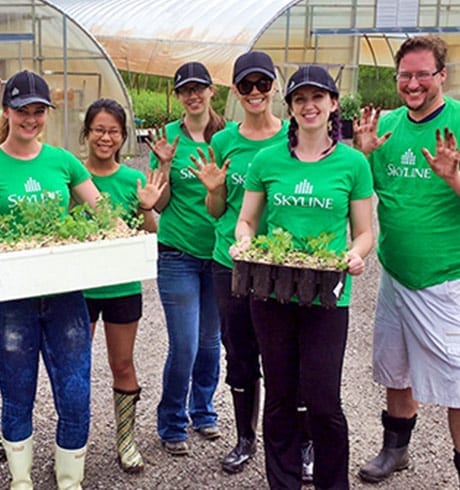 Six Skyliners pose with newly planted trees