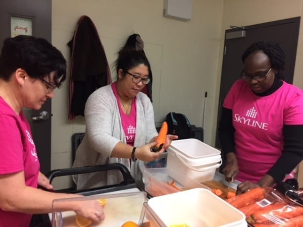 Three Skyline employees cutting carrots