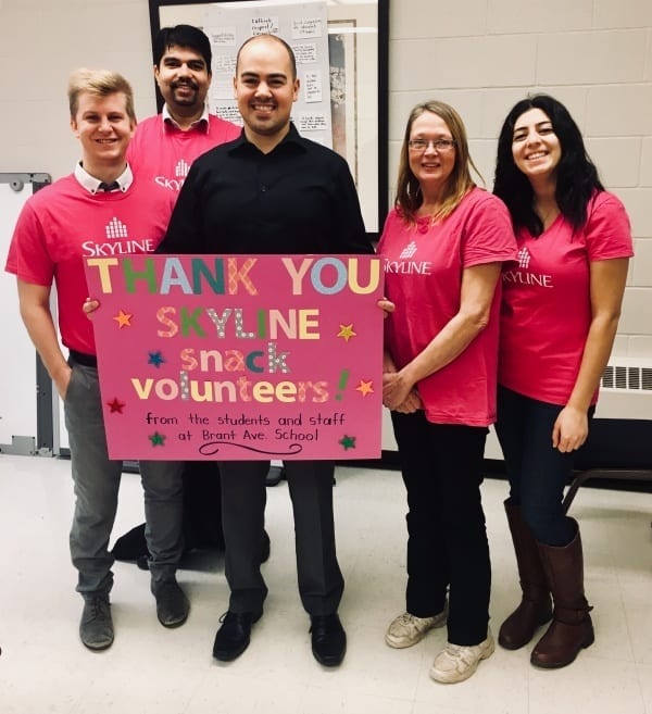 Five people holding a large sign that says Thank you to the volunteers