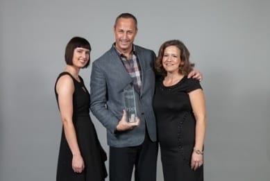 Three Skyline executives pose with the trophy