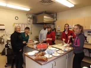 Six Skyline employees prepare dinner in a kitchen